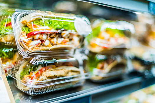 CircuTrayUP - Ressourceneffiziente Kreislaufführung für PET Trays In PET-Trays verpackte Hühnchensandwiches in einem Supermarktregal.